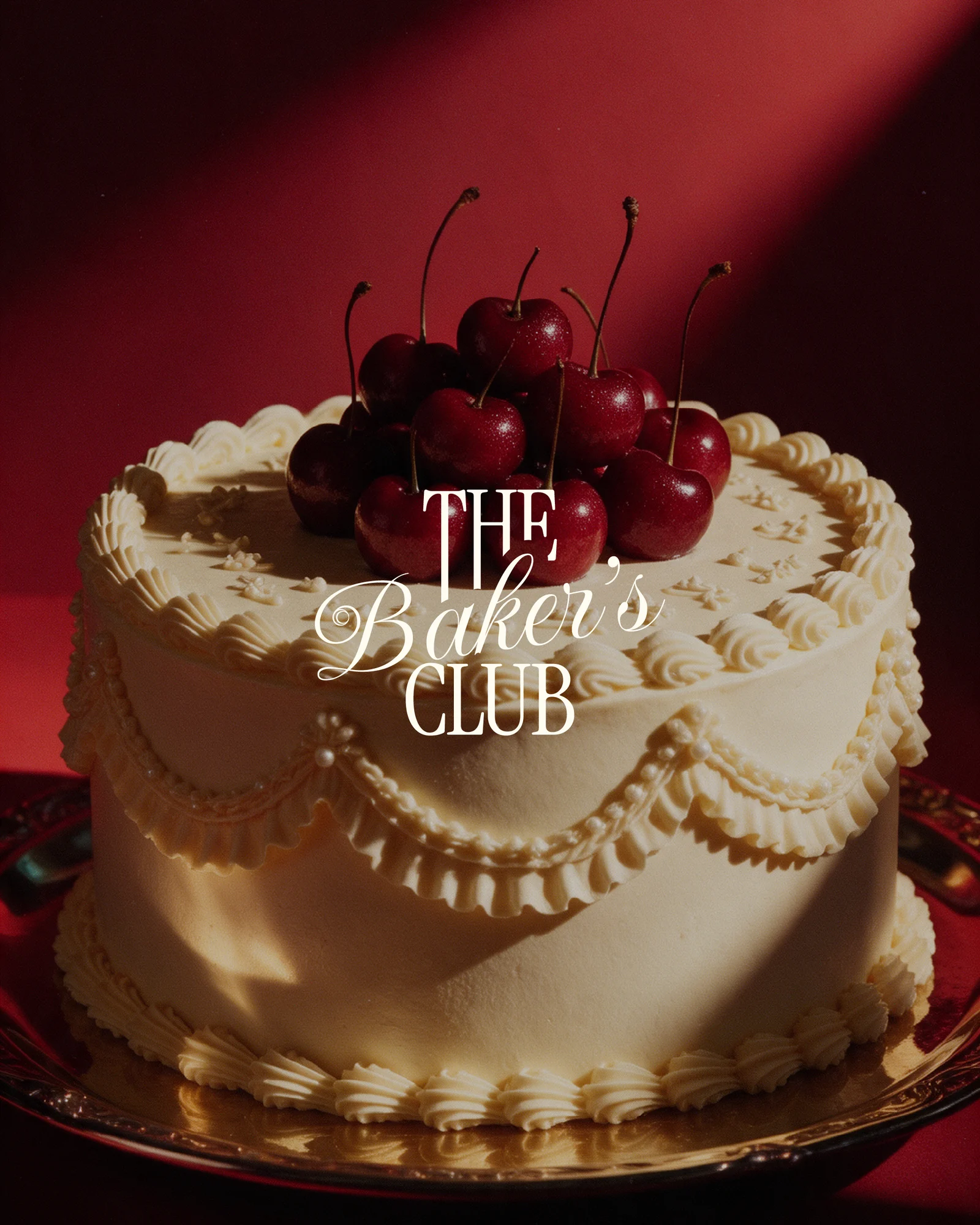 The Baker’s Club lettering over a cherry-topped cake against a red backdrop
